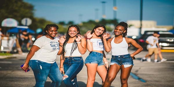 Group of students standing in an FIU parking lot posing for a picture. 