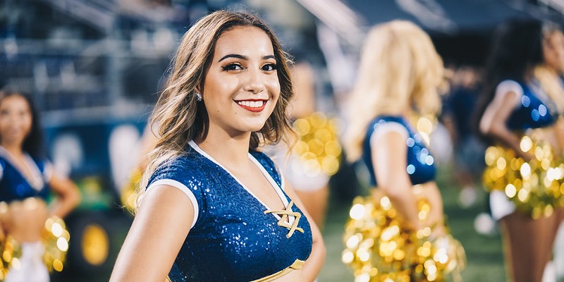 Two cheerleaders at a FIU football game posing and smiling for the camera. 