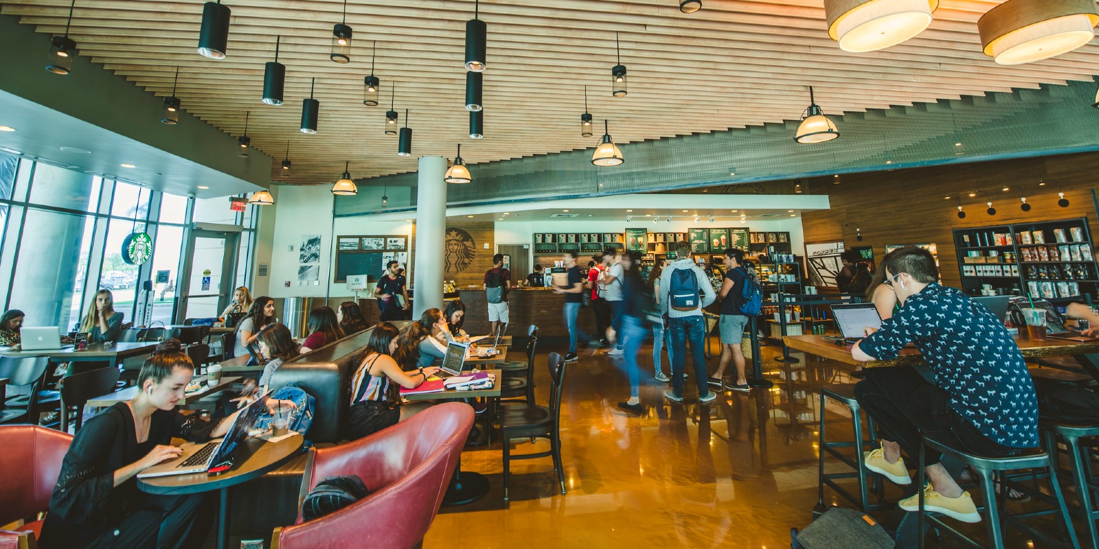 The Starbucks lounge at the Mango Building on FIU featuring a multitude of students ordering coffee and studying. 