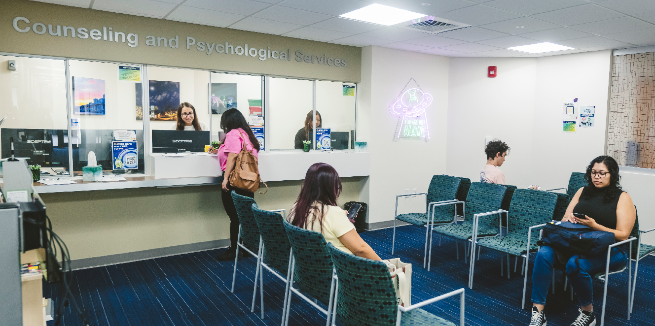 Kiwi, a figurative mascot for the CAPS office at FIU is featured as a figurine on a desk next to a laptop. 