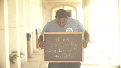 Students hold signs about how they attack cancer