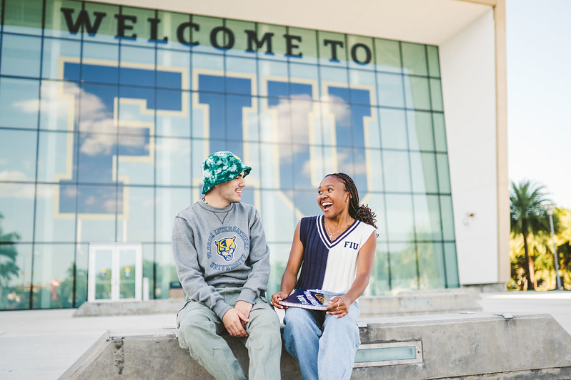 Students in front of Welcome to FIU sign