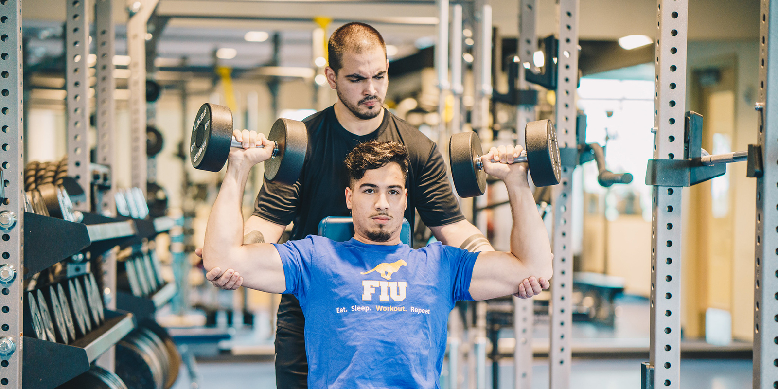 Two men working out at the gym at FIU. 